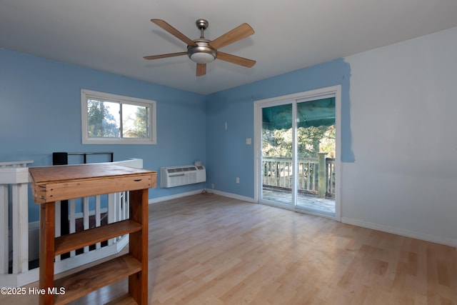 interior space featuring access to outside, a wall unit AC, ceiling fan, and light hardwood / wood-style flooring