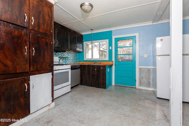 kitchen with decorative backsplash, sink, hanging light fixtures, and white appliances