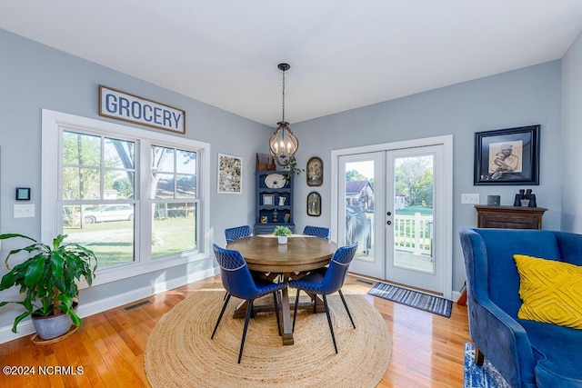 dining room with light wood-style flooring, visible vents, baseboards, and french doors