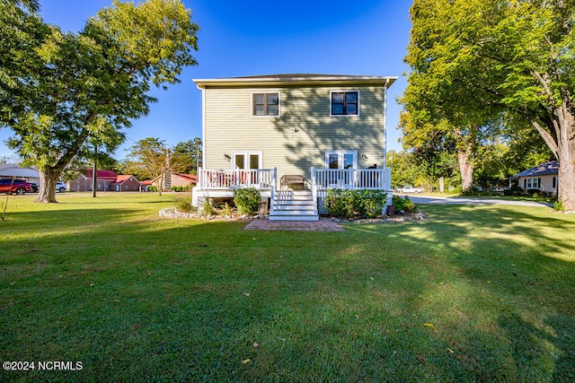 rear view of property with a yard and a wooden deck