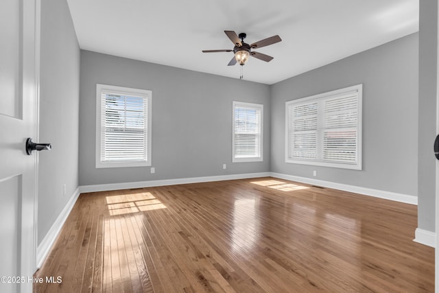 unfurnished bedroom with visible vents, a ceiling fan, hardwood / wood-style flooring, and baseboards