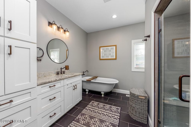 bathroom with tile patterned flooring, vanity, baseboards, a soaking tub, and a shower stall