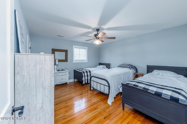 bedroom with visible vents, ceiling fan, and hardwood / wood-style flooring