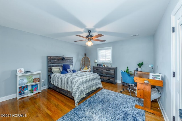 bedroom featuring visible vents, baseboards, and wood finished floors