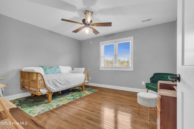 bedroom featuring visible vents, ceiling fan, hardwood / wood-style flooring, and baseboards