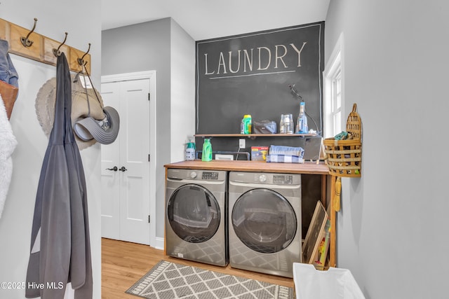 washroom with laundry area, wood finished floors, and washing machine and clothes dryer