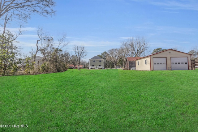 view of yard with a garage and an outbuilding