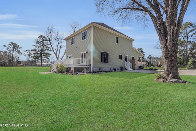 back of property with a lawn and a wooden deck