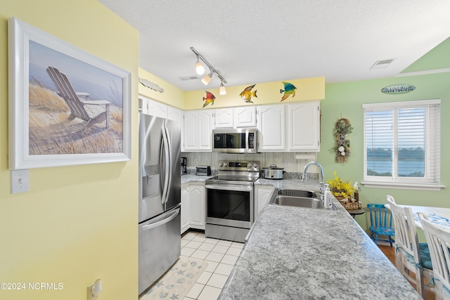 kitchen featuring white cabinets, stainless steel appliances, sink, and a textured ceiling