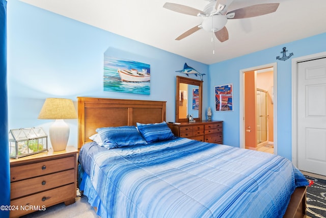 bedroom featuring ensuite bath, light colored carpet, and ceiling fan