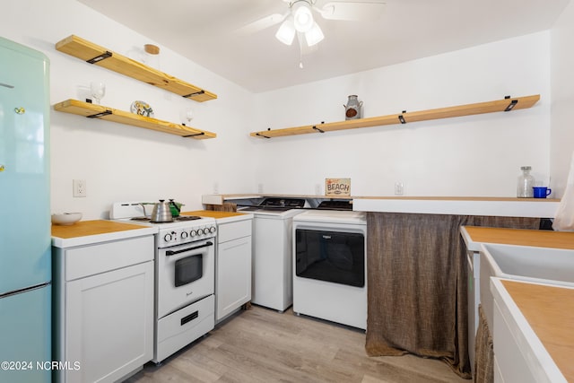 kitchen featuring ceiling fan, light wood-type flooring, washing machine and clothes dryer, and white appliances