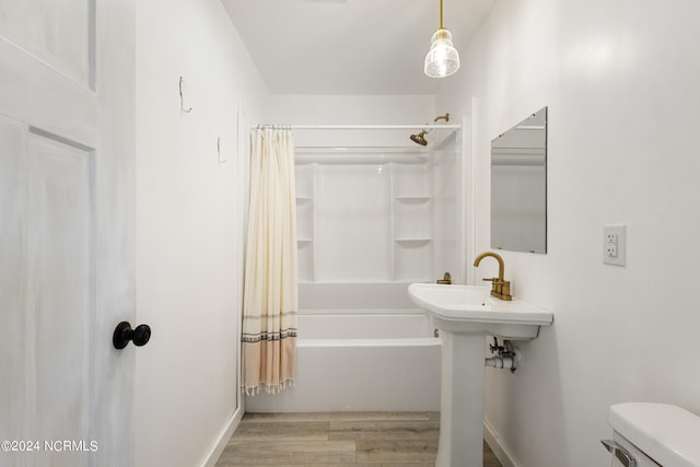 bathroom with shower / tub combo, hardwood / wood-style floors, and toilet