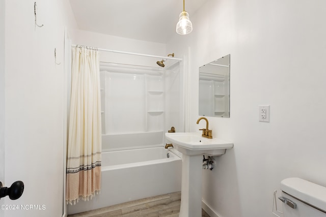 bathroom featuring toilet, hardwood / wood-style floors, and shower / tub combo with curtain