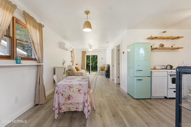 dining space with light wood-type flooring, a wealth of natural light, and a wall mounted air conditioner