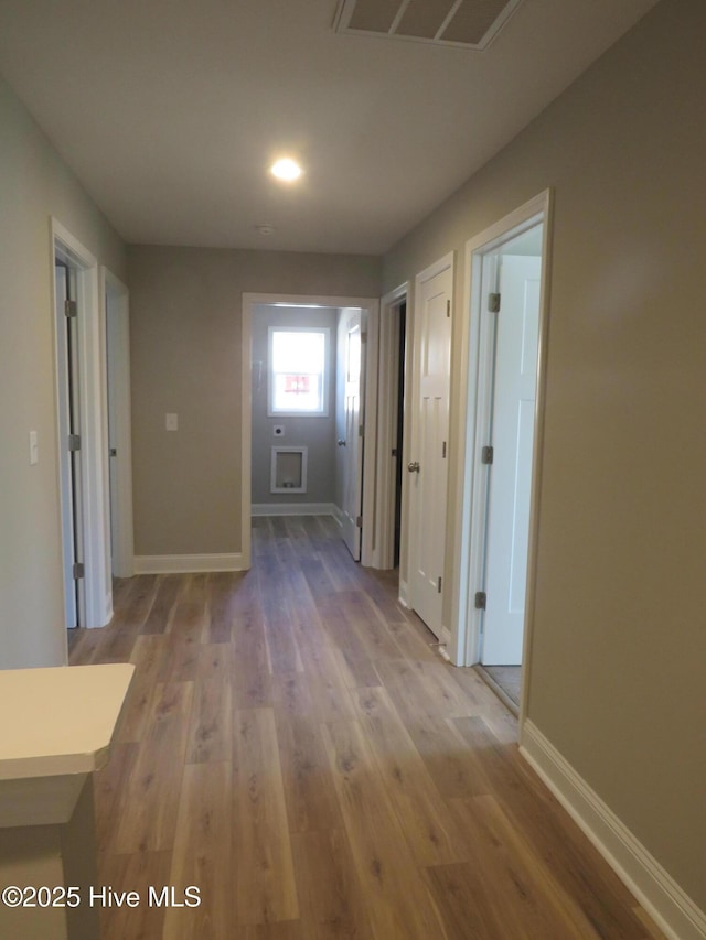 hallway with hardwood / wood-style flooring