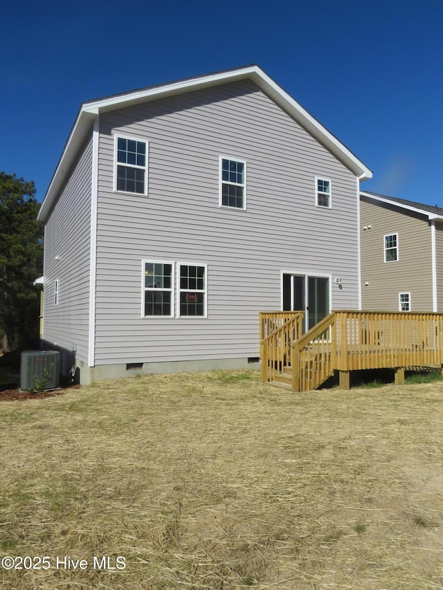 back of property with cooling unit, a yard, and a wooden deck