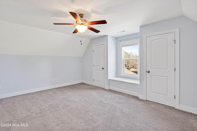 additional living space featuring light colored carpet, vaulted ceiling, and ceiling fan