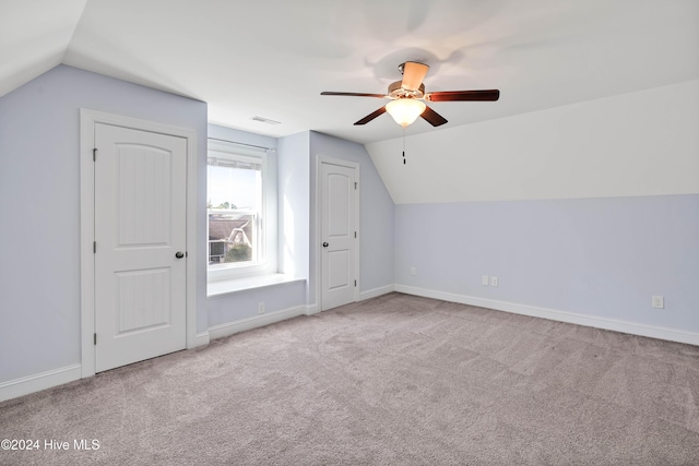 additional living space featuring light colored carpet, vaulted ceiling, and ceiling fan