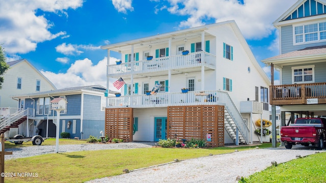 beach home with a front yard, stairway, a carport, and driveway