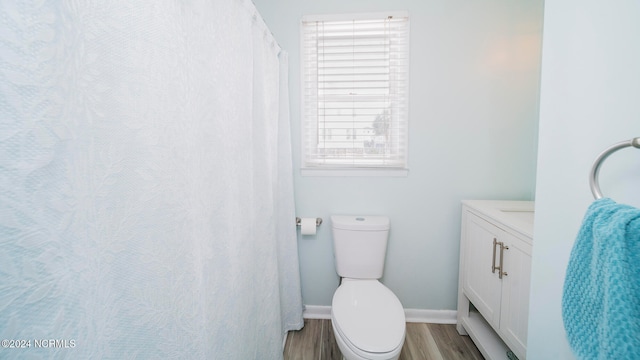 bathroom with wood-type flooring, vanity, and toilet