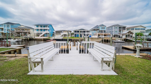 dock area featuring a residential view, a lawn, and a water view