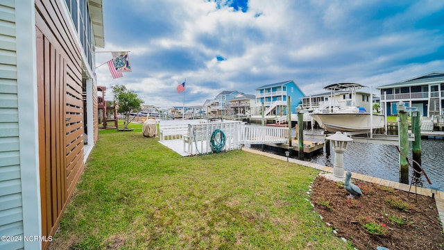 view of dock with a yard, a water view, and boat lift