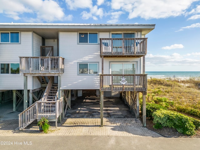 view of front of house featuring a carport, a water view, and a beach view