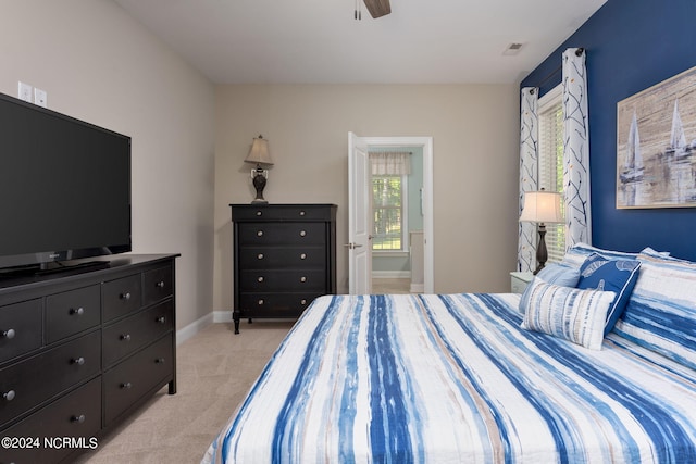 bedroom featuring ceiling fan, light carpet, and connected bathroom