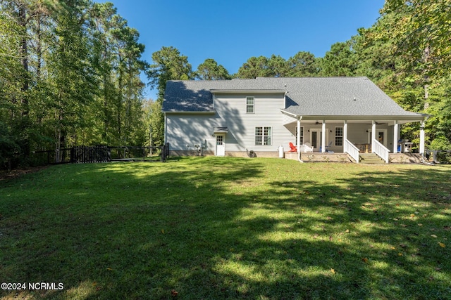 rear view of property with a porch and a yard