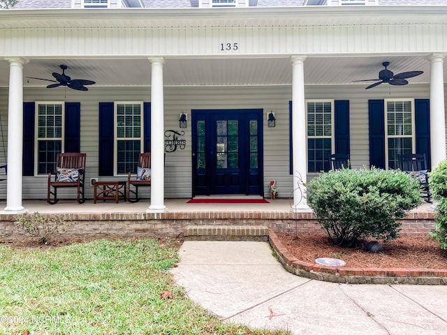 view of exterior entry featuring a porch and ceiling fan