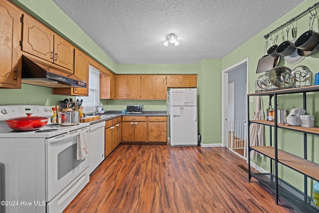 kitchen with dark hardwood / wood-style flooring, a textured ceiling, and white appliances