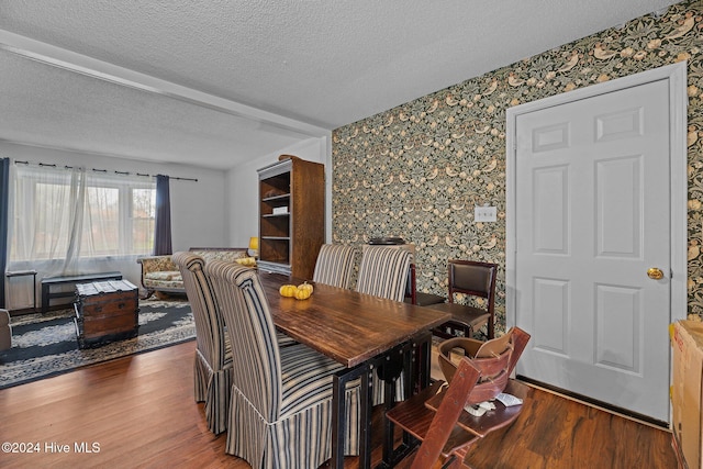 dining room featuring dark hardwood / wood-style flooring and a textured ceiling