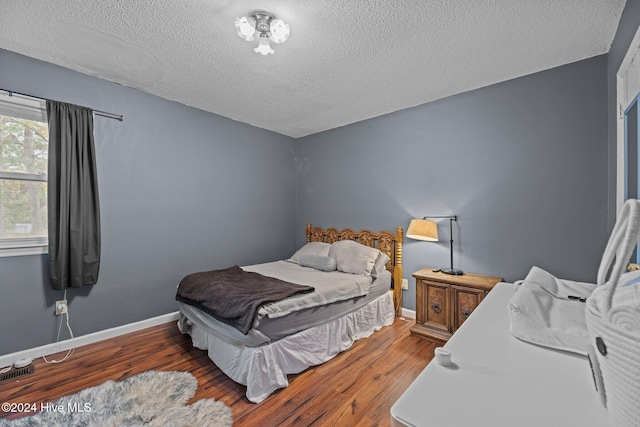 bedroom featuring dark hardwood / wood-style floors and a textured ceiling