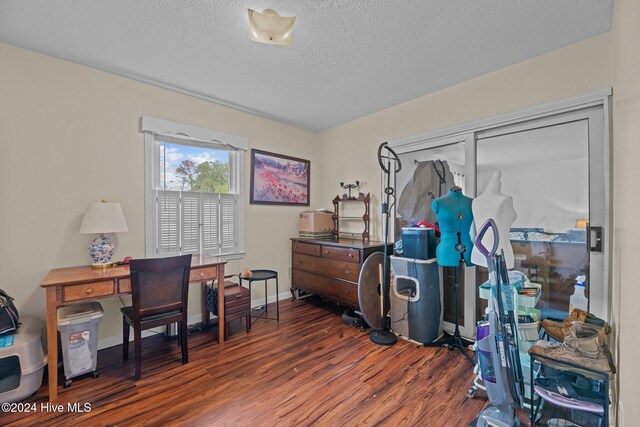 office area with dark wood-type flooring and a textured ceiling