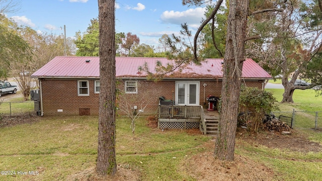 rear view of property featuring a lawn and a deck