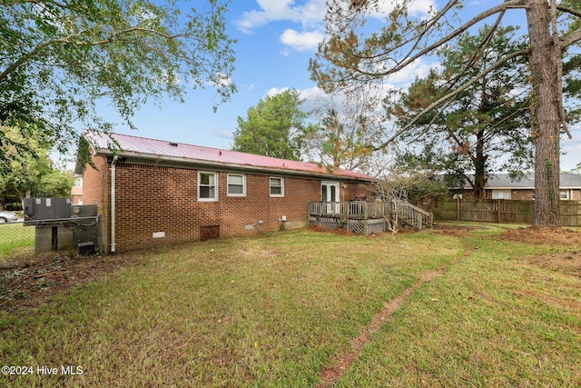 rear view of property with a yard and a deck