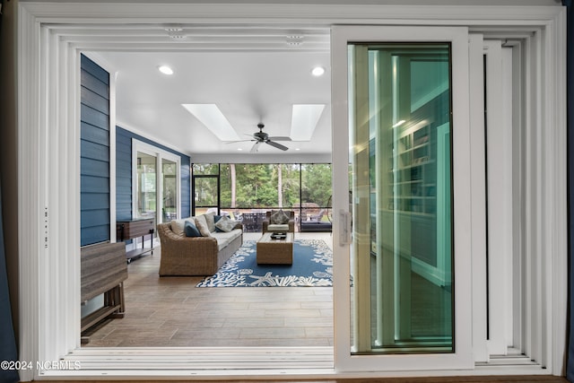 living room featuring ceiling fan and a skylight