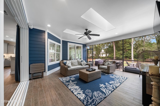 sunroom / solarium featuring ceiling fan, a skylight, and a wealth of natural light