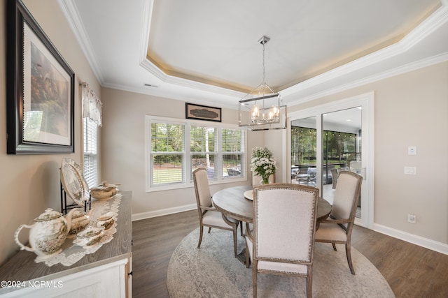 dining area with a tray ceiling, dark wood-type flooring, and a chandelier