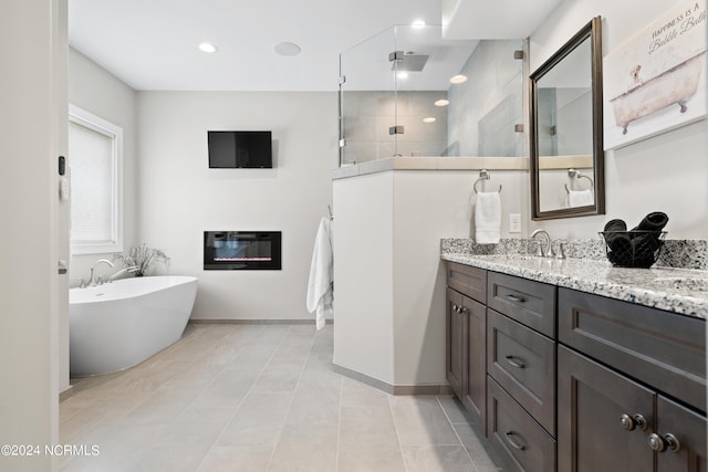 bathroom featuring shower with separate bathtub, vanity, and tile patterned floors