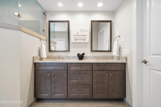 bathroom featuring vanity, a shower, and tile patterned flooring