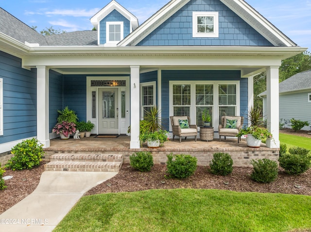 view of exterior entry featuring covered porch