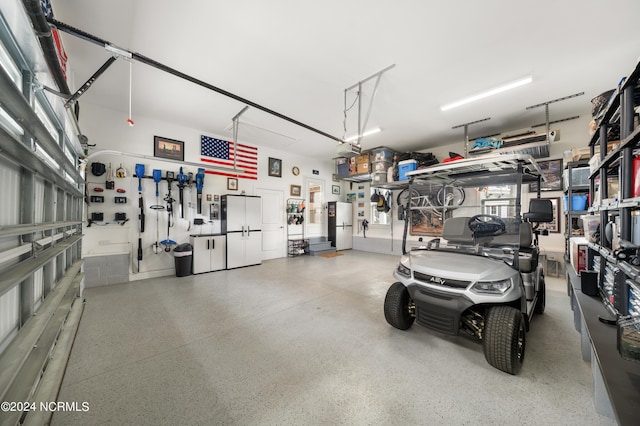 garage with a garage door opener and white fridge