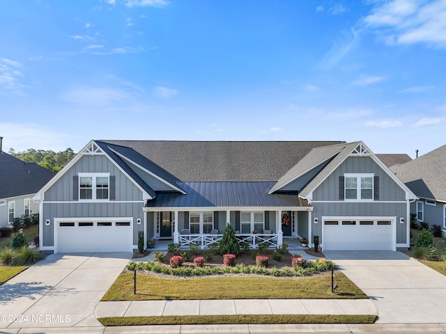 view of front of house with a front lawn, covered porch, and a garage