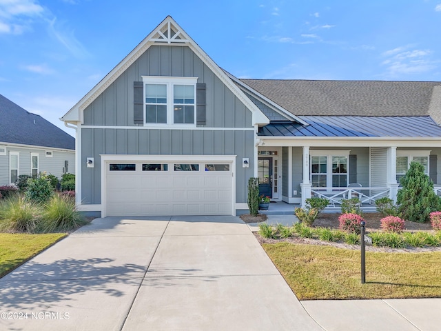 view of front facade featuring a front yard, a garage, and covered porch