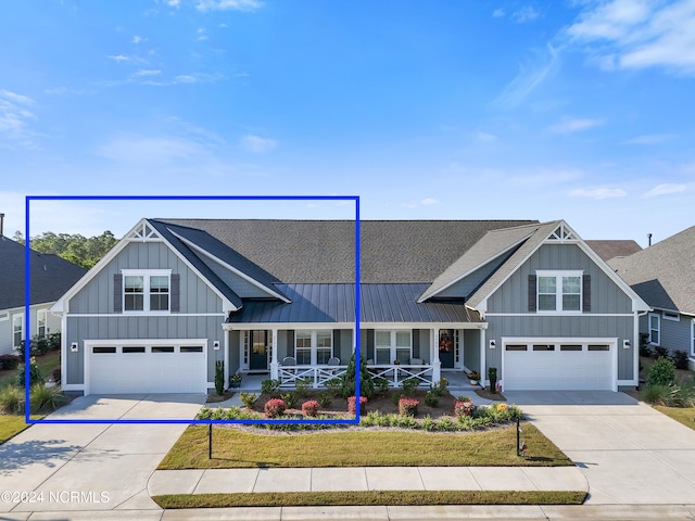 view of front of property with a garage, a front lawn, and covered porch