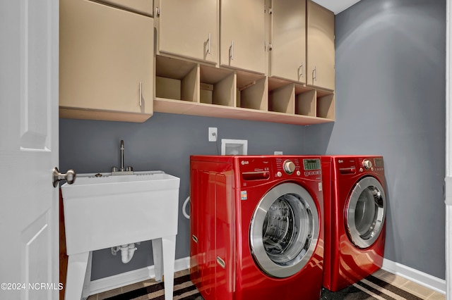 laundry area with washing machine and clothes dryer and cabinets