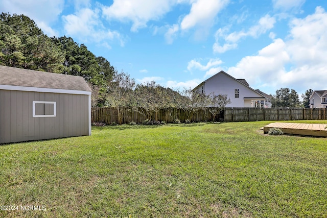 view of yard featuring a deck and a storage unit