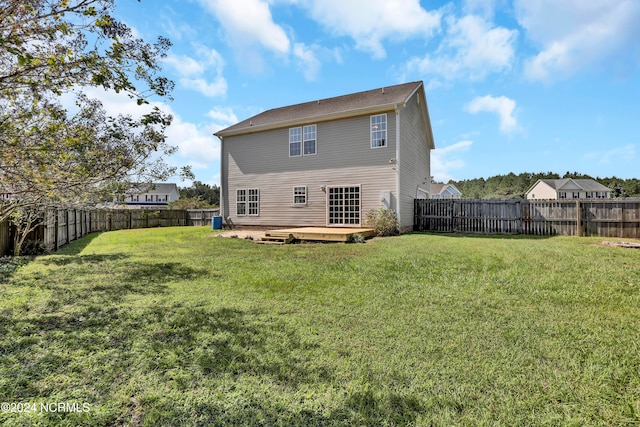 back of property featuring a lawn and a wooden deck