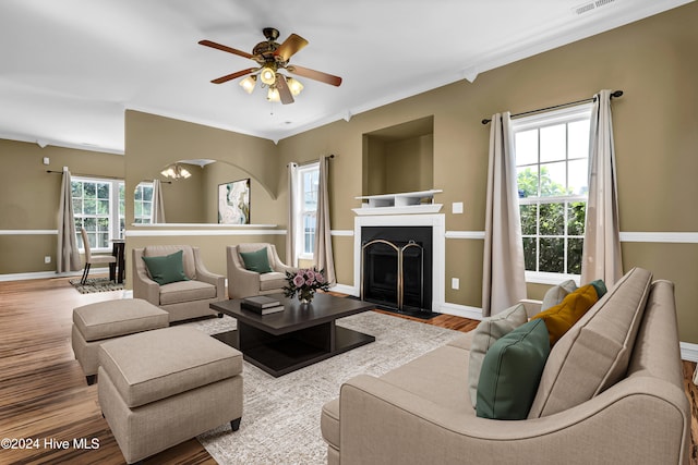 living room with hardwood / wood-style flooring, a wealth of natural light, ornamental molding, and ceiling fan